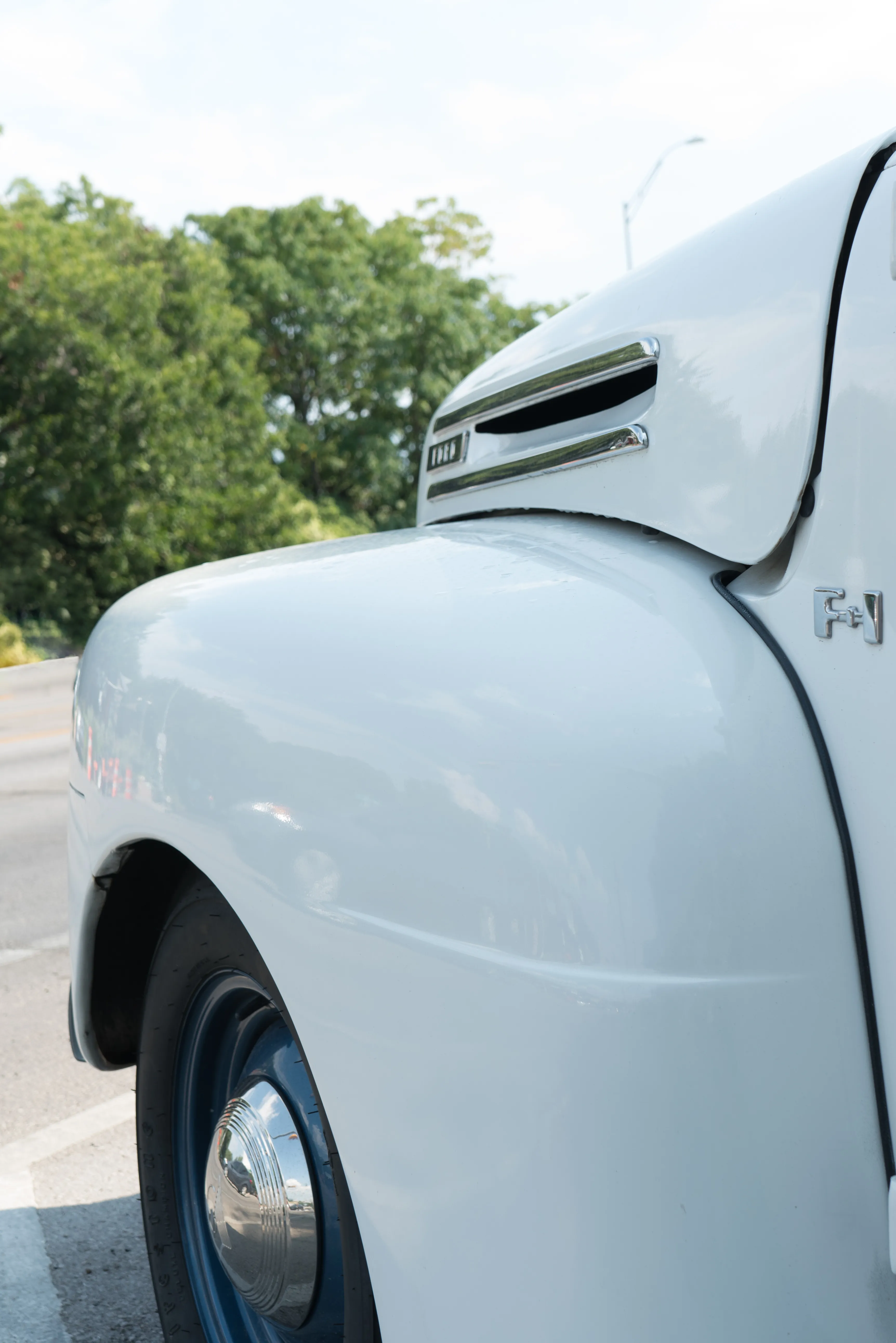 The front fender of a white classic car